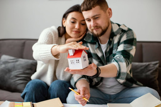 casal feliz olhando uma casa