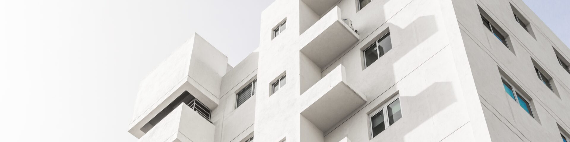 imagem da fachada de um prédio de apartamentos residenciais na cobra branc, ao fundo um céu claro.