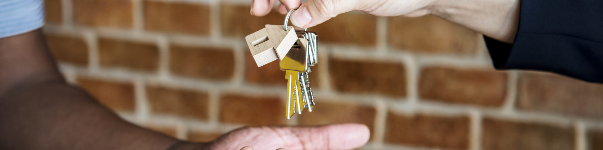 mão estendida recebendo a chave de uma casa