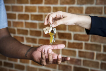 mão estendida recebendo a chave de uma casa